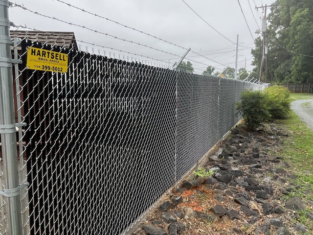 chain link with privacy slats and barbed wire