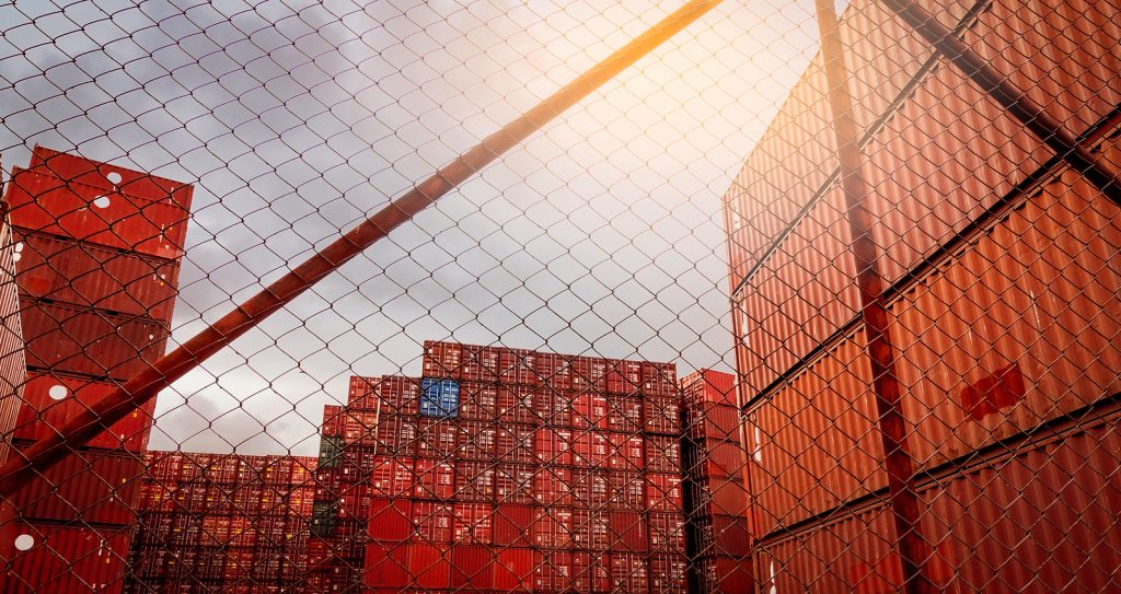 View From Fence Of Red Container Stacked. Container Logistics. C